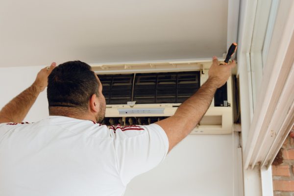 Technical man in an apartment starting air conditioning service